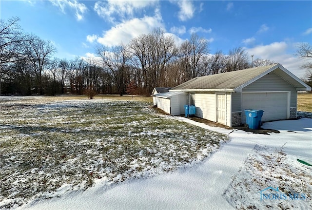 yard covered in snow featuring a garage