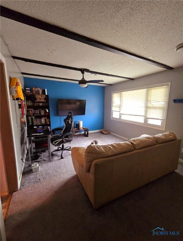 carpeted living room featuring ceiling fan and a textured ceiling