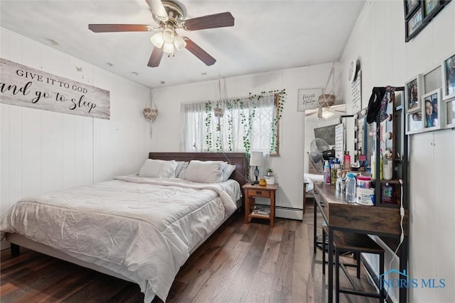 bedroom with a baseboard heating unit, dark hardwood / wood-style floors, and ceiling fan