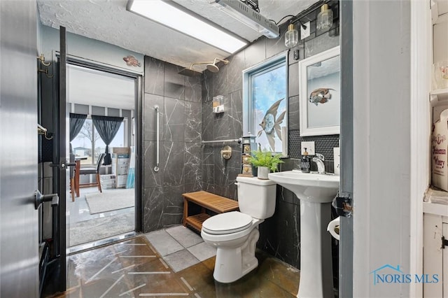 bathroom with toilet, tile walls, and a shower