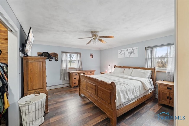 bedroom featuring dark wood-type flooring, a baseboard radiator, and ceiling fan