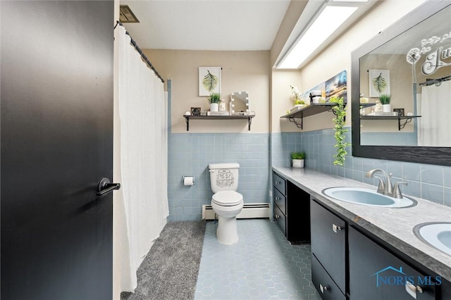 bathroom featuring a baseboard radiator, vanity, toilet, and tile walls