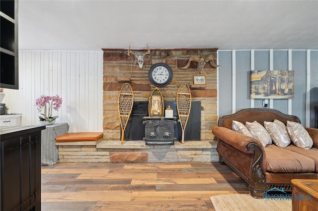 living room with wood-type flooring and a wood stove