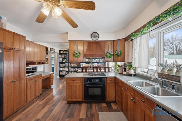 kitchen with black oven, sink, stainless steel dishwasher, kitchen peninsula, and custom range hood