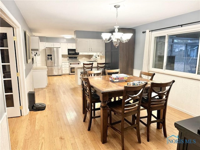 dining room featuring a notable chandelier, light hardwood / wood-style flooring, and sink