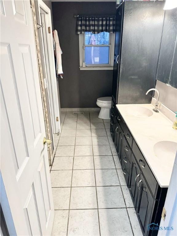 bathroom featuring vanity, tile patterned floors, and toilet