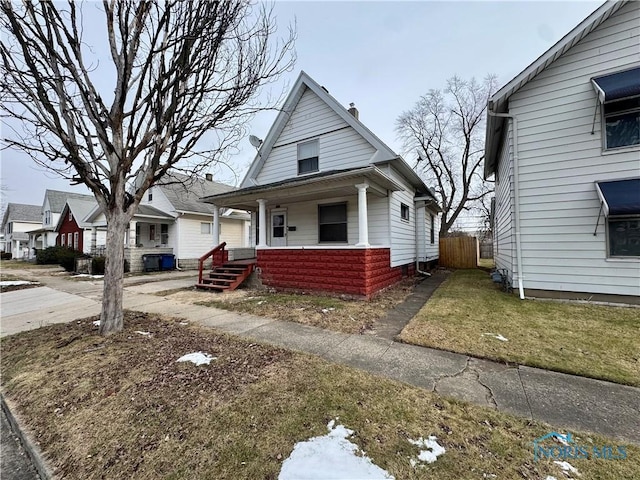 view of front of house with a porch, central AC, and a front yard