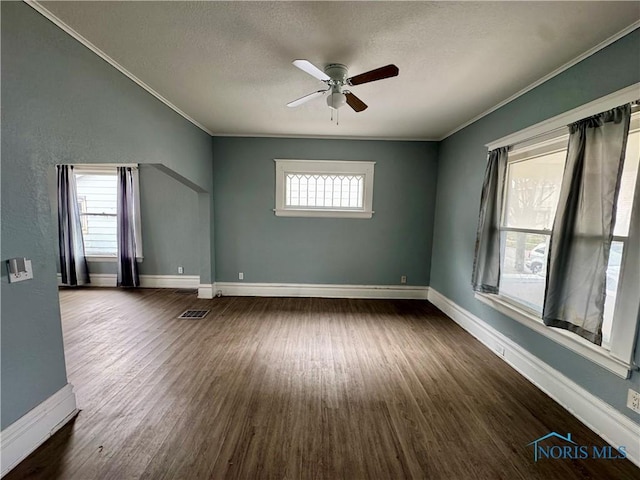 empty room featuring crown molding, dark hardwood / wood-style floors, and a textured ceiling