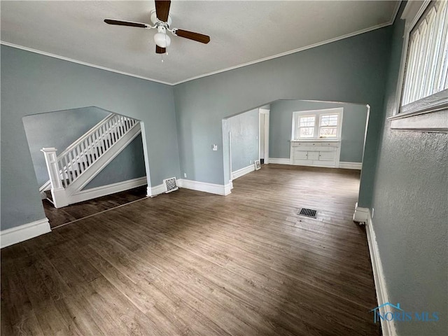 unfurnished living room with dark wood-type flooring, ceiling fan, and ornamental molding