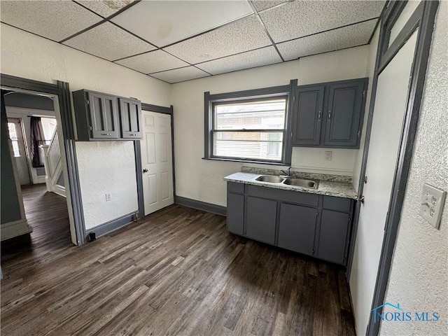 kitchen featuring gray cabinets, sink, dark wood-type flooring, and a drop ceiling