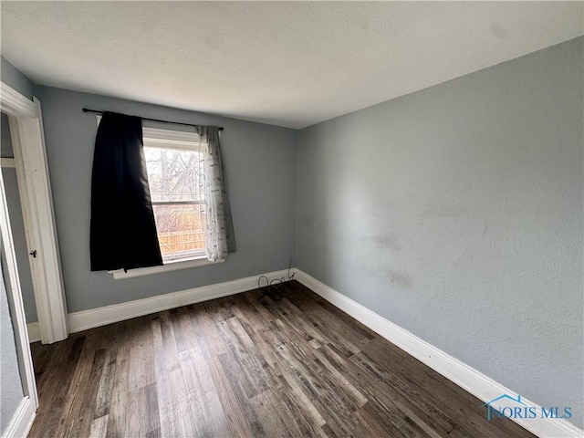 empty room with dark hardwood / wood-style floors