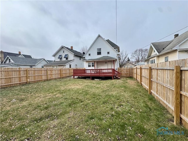 back of property featuring a lawn and a deck