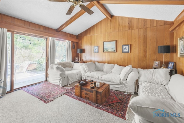 living room with carpet floors, lofted ceiling with beams, and wood walls