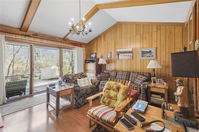 living room with vaulted ceiling with beams, a notable chandelier, and wooden walls