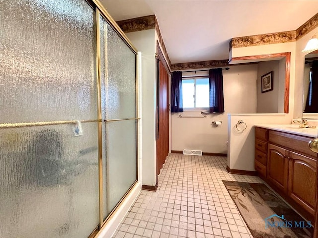 bathroom featuring tile patterned flooring, vanity, and walk in shower