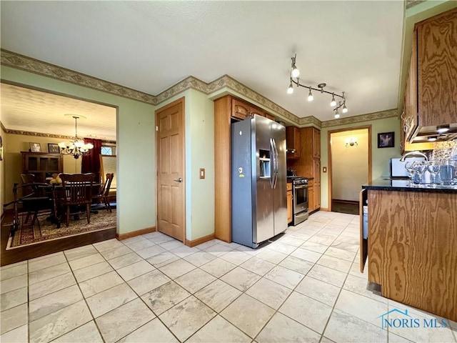 kitchen featuring a notable chandelier, light tile patterned floors, hanging light fixtures, and appliances with stainless steel finishes