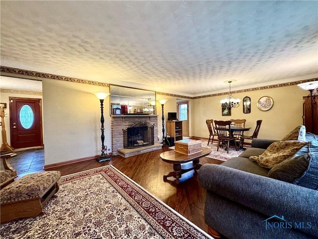 living room with hardwood / wood-style floors, a textured ceiling, and a notable chandelier