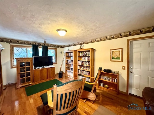 living area featuring hardwood / wood-style floors and a textured ceiling