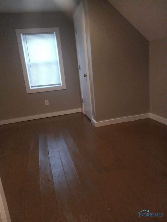 bonus room featuring dark wood-type flooring and lofted ceiling