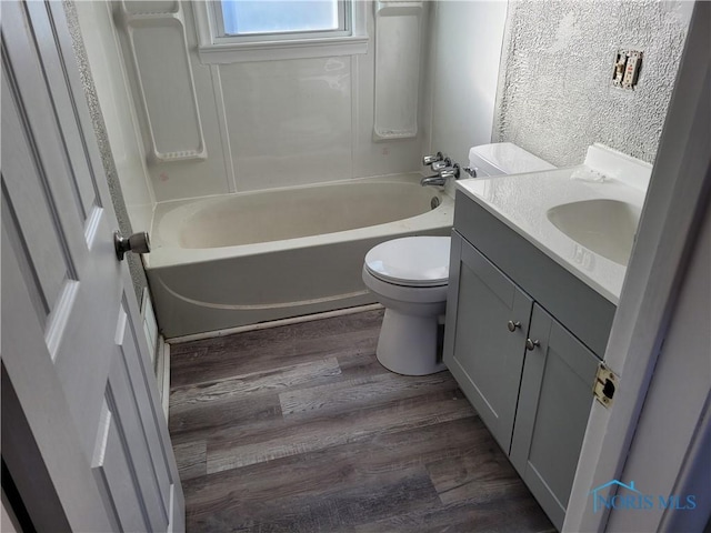 full bathroom featuring vanity, wood-type flooring,  shower combination, and toilet