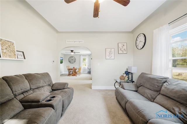 living room with a wealth of natural light, light colored carpet, and ceiling fan