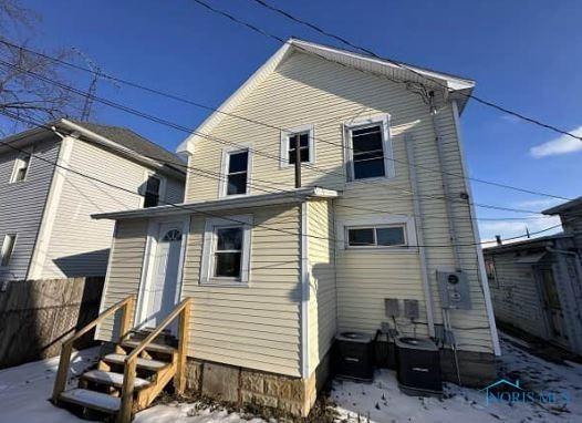 snow covered house featuring central air condition unit