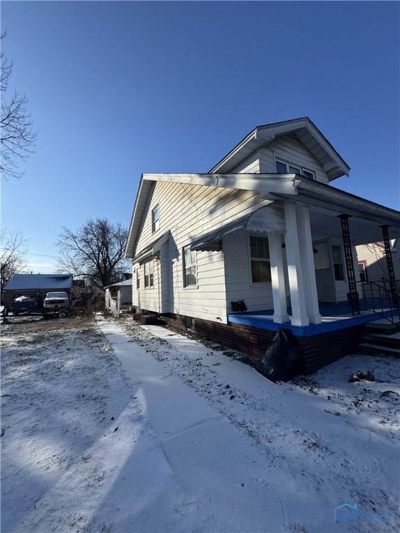 view of snow covered exterior featuring covered porch