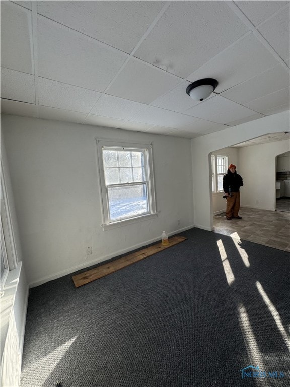 carpeted spare room with a drop ceiling