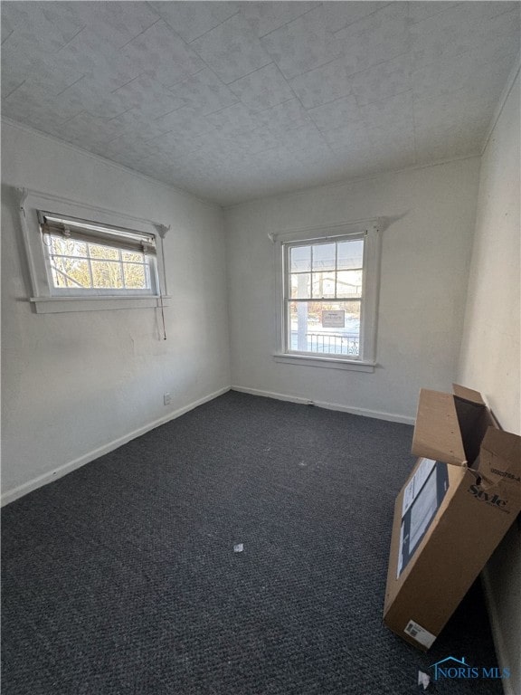 unfurnished room with dark colored carpet