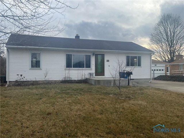 single story home with a garage and a front lawn