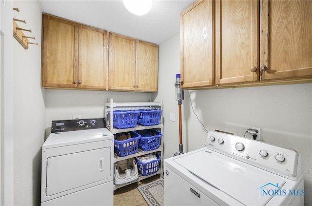 washroom with cabinets and washing machine and dryer