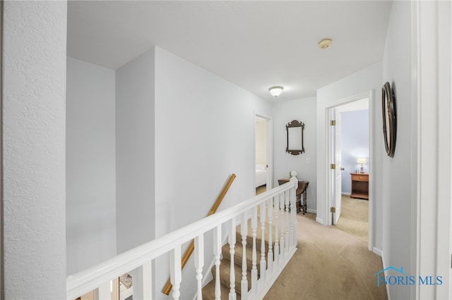 hallway featuring light colored carpet