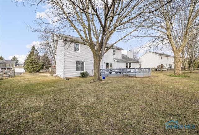 rear view of property with a wooden deck and a yard