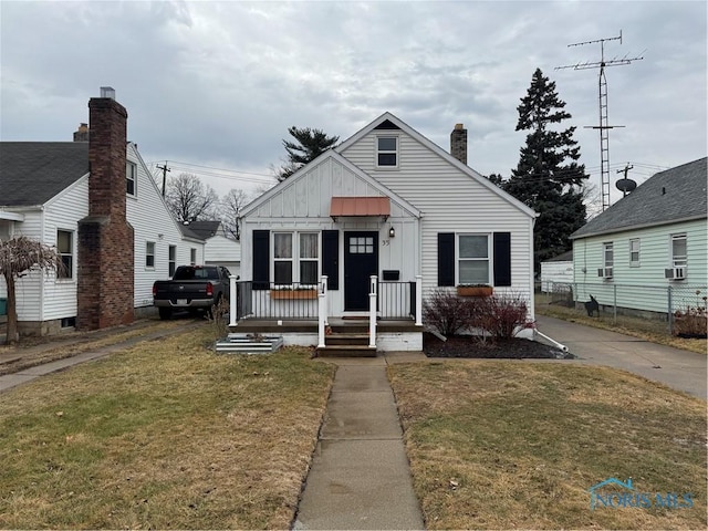 bungalow featuring cooling unit and a front lawn