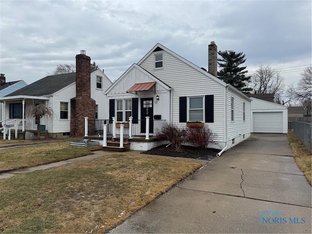 view of front of home featuring a garage, an outdoor structure, and a front lawn