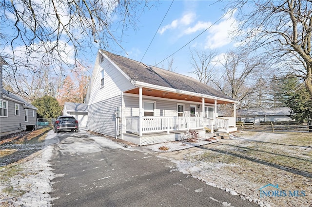 bungalow-style house with an outbuilding, a garage, and a porch