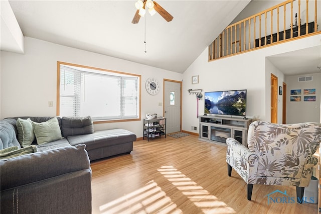 living room with ceiling fan, high vaulted ceiling, and light hardwood / wood-style flooring