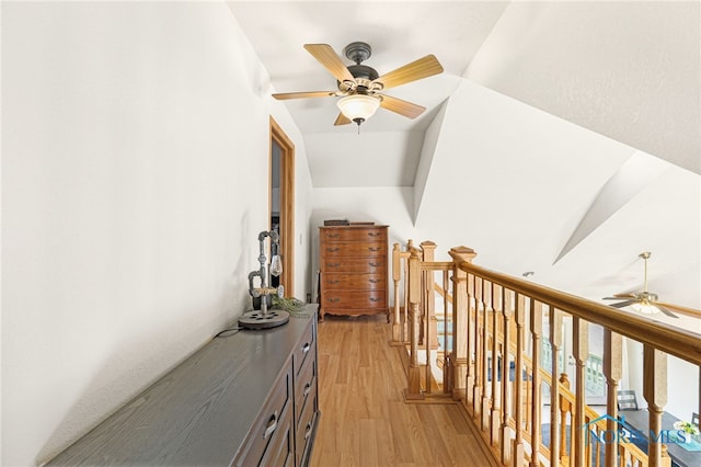 hallway with vaulted ceiling and light hardwood / wood-style floors