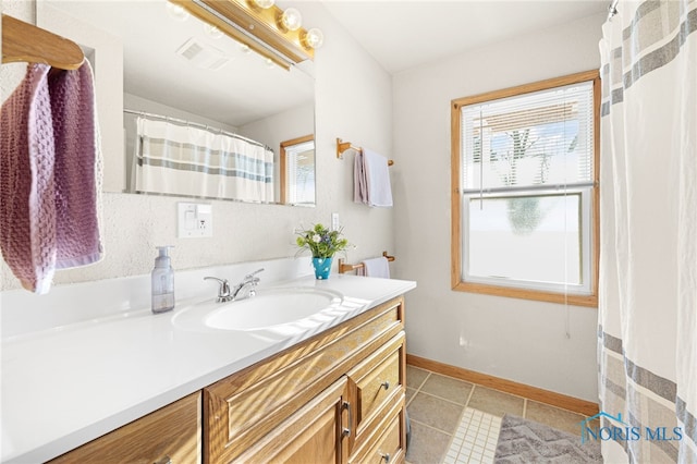 bathroom with vanity, a wealth of natural light, and tile patterned floors