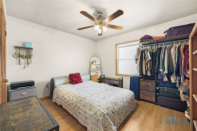 bedroom featuring ceiling fan, light hardwood / wood-style floors, and a closet