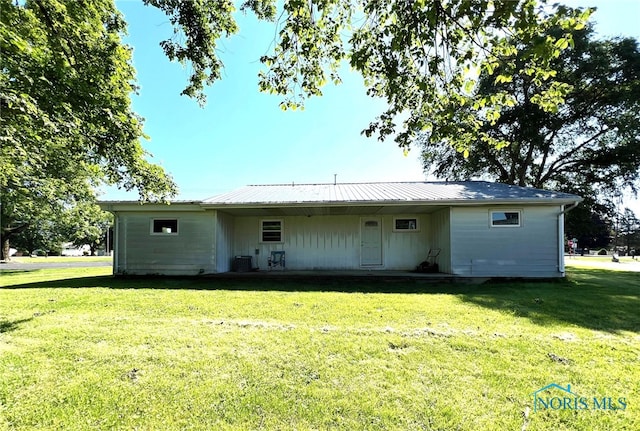 back of house featuring a lawn