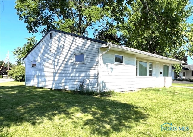 view of side of home featuring a yard