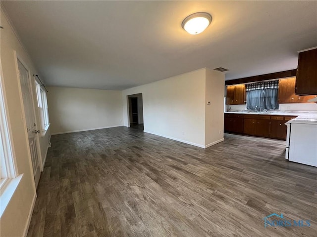 unfurnished living room with dark hardwood / wood-style flooring and sink