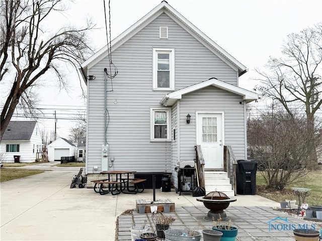 rear view of house featuring a patio and an outdoor fire pit