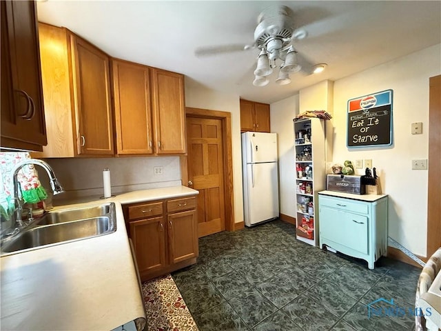 kitchen featuring white refrigerator, sink, and ceiling fan