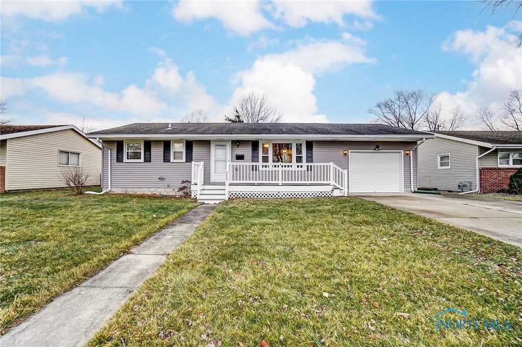 ranch-style house featuring a garage, a front yard, and covered porch