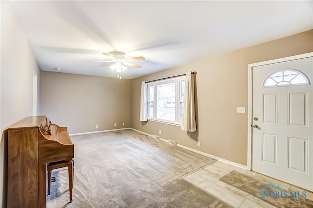 foyer entrance featuring light colored carpet and ceiling fan