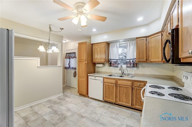 kitchen featuring hanging light fixtures, white appliances, ceiling fan with notable chandelier, and sink