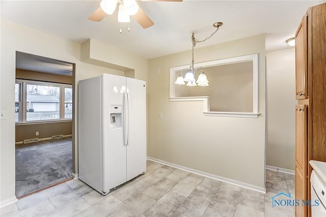 kitchen featuring hanging light fixtures, ceiling fan with notable chandelier, and white refrigerator with ice dispenser