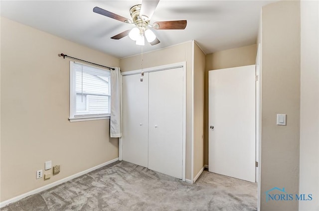 unfurnished bedroom with ceiling fan, a closet, and light carpet